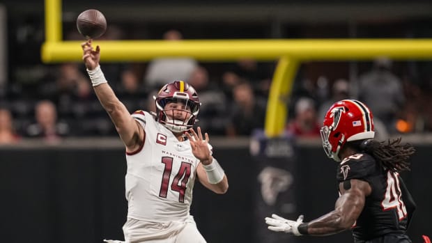 Washington Commanders quarterback Sam Howell (14) passes over Atlanta Falcons linebacker Bud Dupree (48) during the first quarter at Mercedes-Benz Stadium.